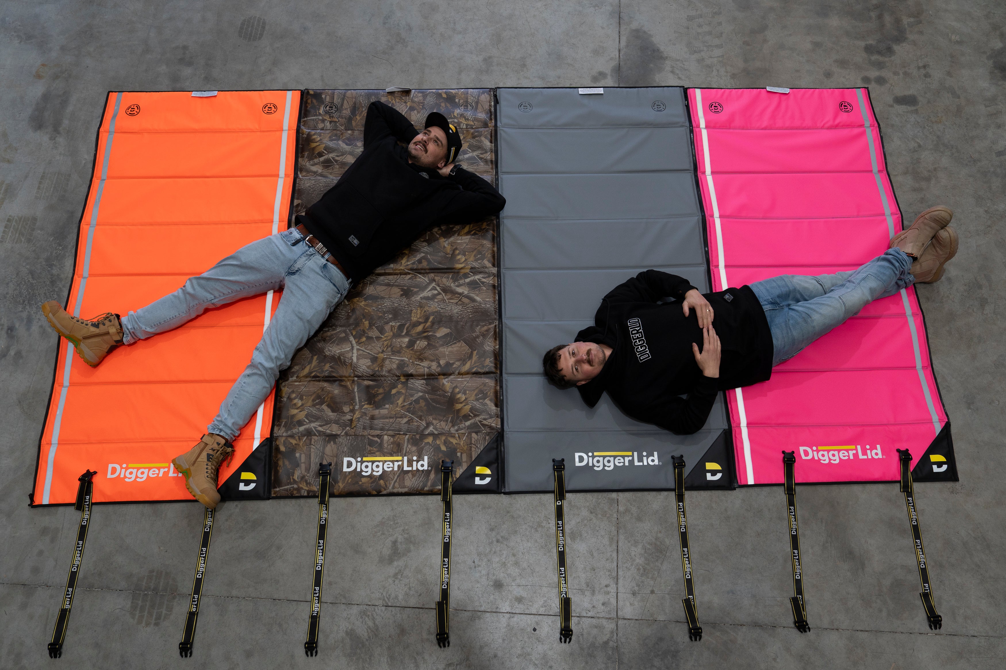 Crew lying across four Pro Mat Plus mats zipped together on a warehouse floor