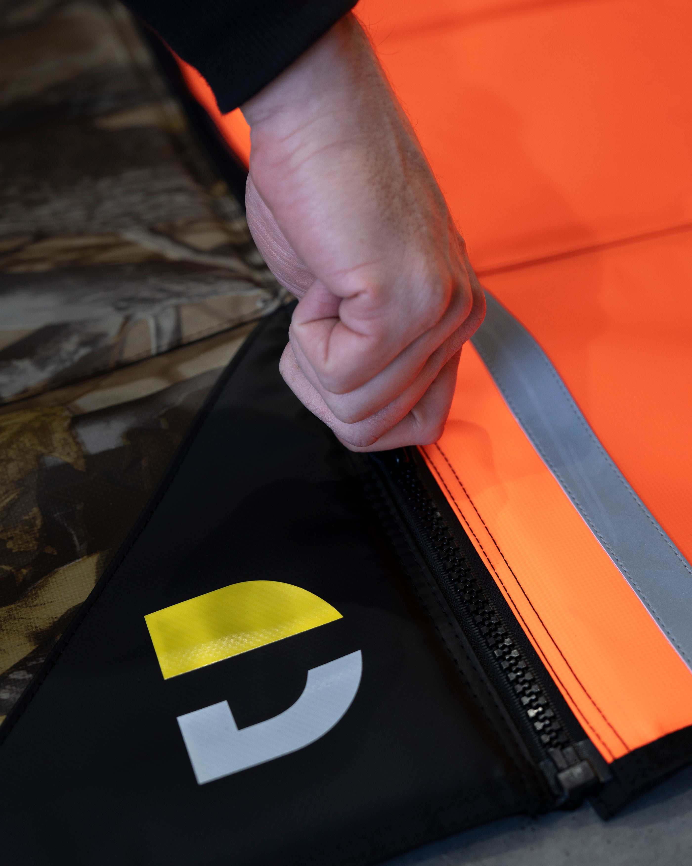 Hand pressing together the side zip joining two Pro Mat Plus mats